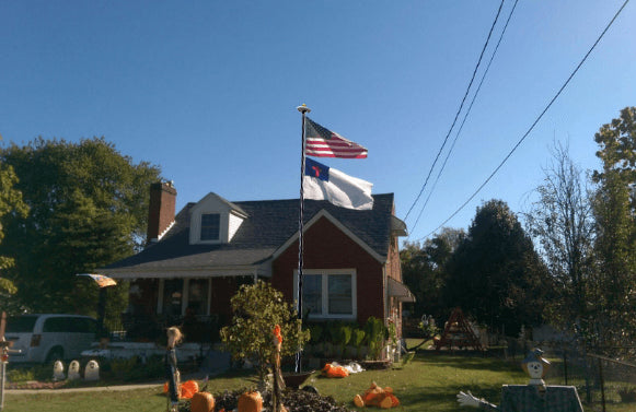 House with the American flag displayed on a flagpole in the front yard.